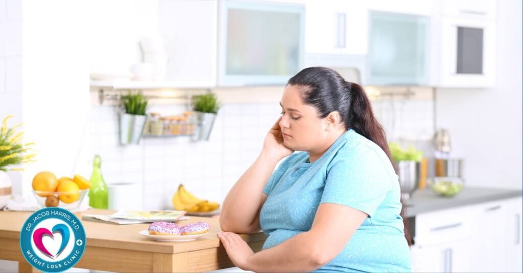 Overweight sad holidays dr.harris a woman sits at a kitchen table, she is portly and obese with her head in her hands looking very sad